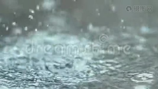 泼水。 雨正滴在水坑里，慢动作视频