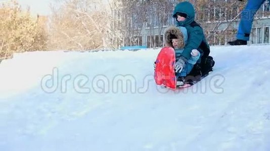 孩子们一起在雪橇上滚下山坡视频