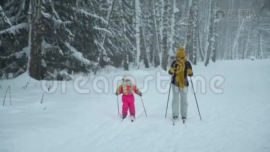 母亲和女儿在雪天滑雪视频