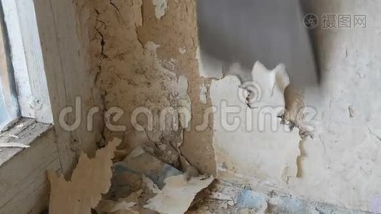 人用专用抹刀剥旧壁纸.. 墙上有黄色破旧的墙纸，家修关门视频