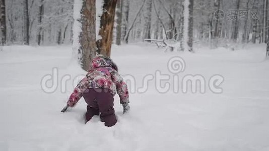 小女孩在雪地里玩耍，冬天在白雪覆盖的公园里给自己扫清了一条小路。 儿童积极追求视频