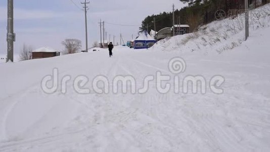 十几岁的男孩在铺满雪的路上奔跑。 冬季公园儿童假期活动。视频