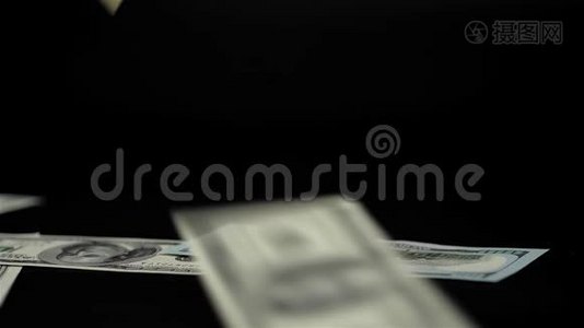 关闭下降的美元钞票视图。 在黑色背景下拍摄的工作室，超级巨幅100美元视频