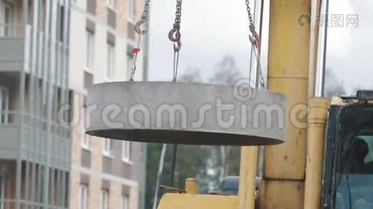 黄色挖掘机在建筑工地的链条上骑混凝土人孔环。视频
