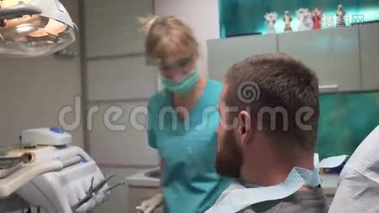 牙医准备牙科器械并与病人交谈。 斯坦迪卡姆。视频
