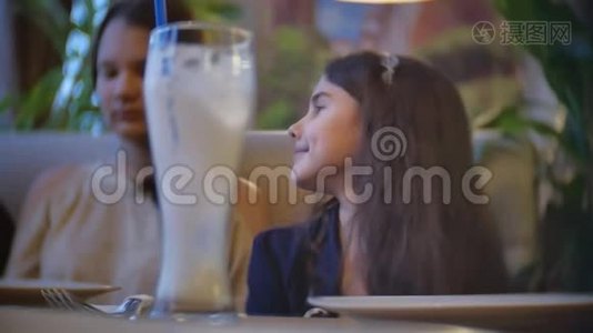 在咖啡馆里交流的女孩是朋友。 青少年儿童坐在咖啡馆快餐慢动作视频视频