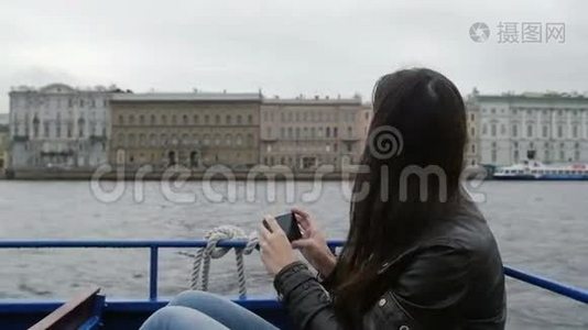 女孩坐在河边的公共汽车上，在河堤上拍摄建筑照片。 一只海鸥在飞来飞去，慢悠悠视频