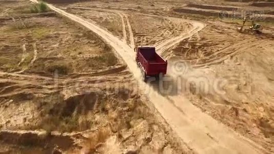 卡车在采石场道路上行驶。 场景。 农村黄泥路自卸车行驶的俯视图.. 大型卡车视频