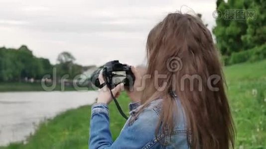 风雨交加，美女游客在河边用专业相机拍摄视频视频