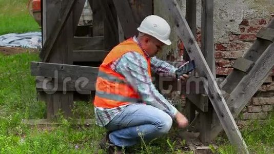 建筑工人检查木脚手架，使用平板电脑视频