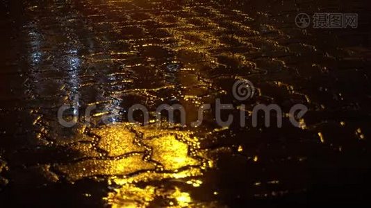 夜街上的雨。水坑里黄色的街灯反射。视频