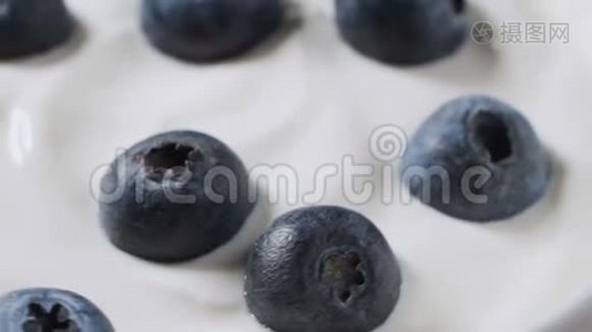 用勺子吃蓝莓和奶油或酸奶，水果背景。视频
