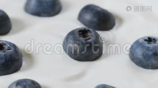 用勺子吃蓝莓和奶油或酸奶，水果背景。视频