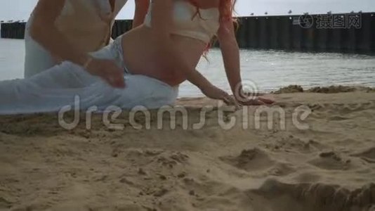 怀孕的夫妇在沙滩上画画。 在海滩上放松的情侣视频