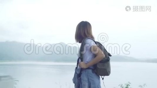 徒步旅行的徒步旅行女背包客，在雨天在湖边的森林里自由行走。视频