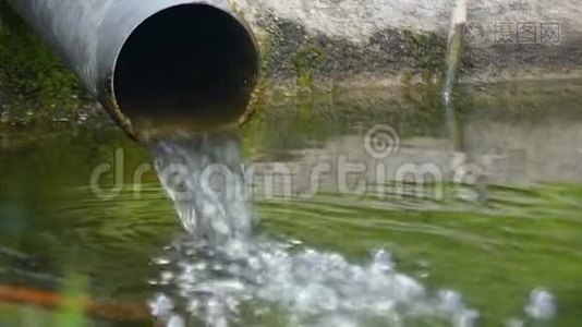 一根宽的管子，溅起的水落到一个湖里视频