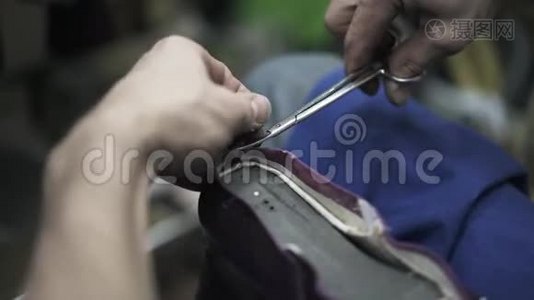 鞋匠用剪刀把皮革剪下来，然后用锤子把它碎视频