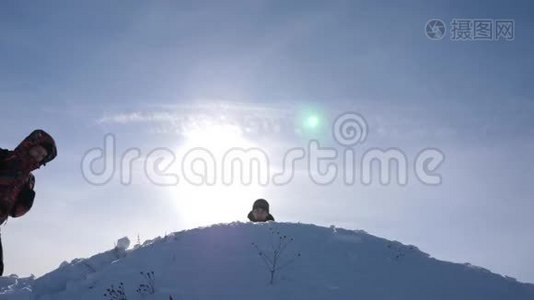 旅行者在成功的基础上相遇。 游客们来到雪山顶上，在黄色的背景下为胜利而欢呼视频