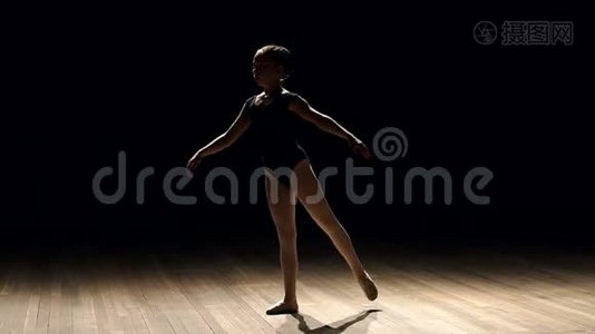 女芭蕾舞演员在黑暗中上台的剪影。视频