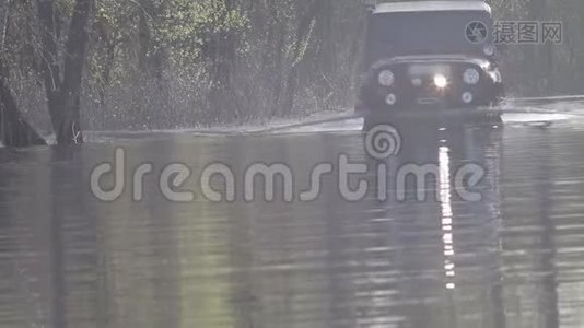 汽车迫使河水流向森林。大雨过后，乡村公路被淹。视频