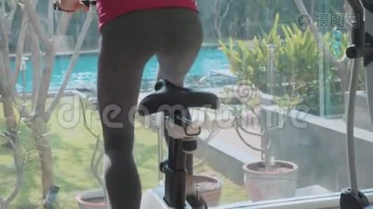 特写女性腿，并在健身房骑着静止自行车慢动作视频
