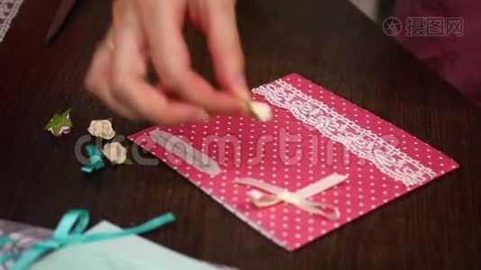 女人用纸、花边和其他临时材料制作明信片。视频