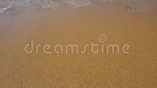 泡沫海浪随着金色的沙子快速地滚到海岸上，冲刷着大海视频