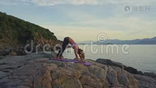 侧景女孩在海滩上做瑜伽姿势，对抗太阳升起视频