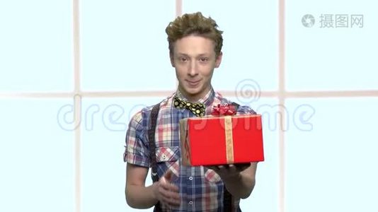 微笑的男孩用丝带送礼物盒。视频