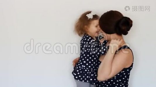 快乐的母亲抱着女儿，拥抱亲吻，表达母爱。抱着孩子的年轻女子视频