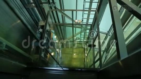 电梯向上移动并到达地面，通过玻璃电梯井观看视频