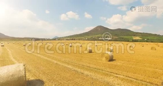 在阳光明媚的乡村里用一捆干草拍摄麦田的空中景色，美丽的山景视频