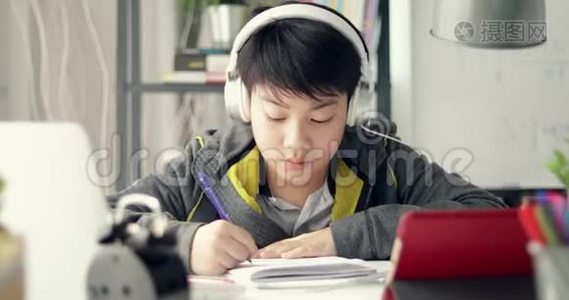 年轻的亚洲青少年学生在家听音乐和做作业，多莉在。视频