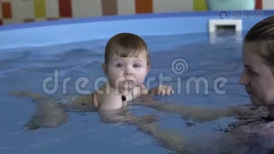 一个小孩子在游泳，看着摄像机视频