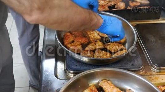 鸡肉腌制后放入煎锅内煎炸，双手厨师翻蓝手套，厨房餐厅.. 从上面看。 肉类视频