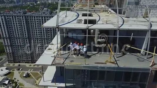 建筑工人、工程师和建筑师在施工现场的成功团队和项目会议上的工人的空中景观视频