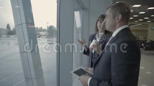 在机场窗口附近与机场员工进行平板电脑会谈的商人视频