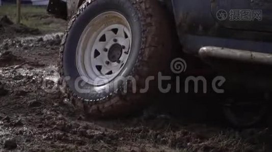 开车的极端条件。 强大的拖车越野车在肮脏的农村道路后，雨后恶劣的天气。 一辆棕色脏车视频