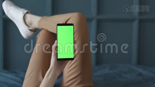 家中卧室中年轻女性手机绿色屏幕的色度键视频