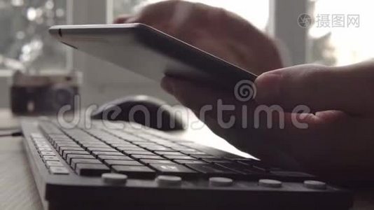 在坐电脑键盘和鼠标的时候，用平板电脑紧紧抓住年轻人的手。 自由摄影师视频