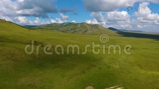 喀喀西亚共和国绿色草地、远处丘陵和多云天空的空中景色。 俄罗斯视频