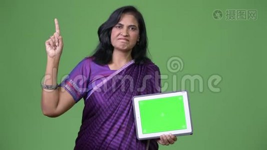 成熟美丽的印度女人展示数字平板电脑，手指视频