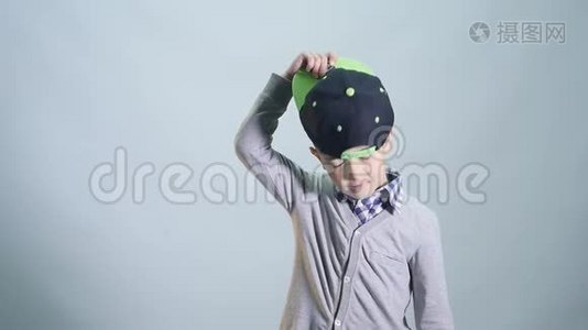 这个男孩戴上帽子，在白色的背景上展示班级隔离视频