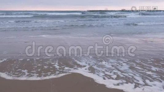 大海里波涛汹涌. 美丽的海景与码头，沙滩在日落。视频