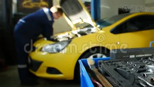 机修工在专业汽车服务部附近修理黄色汽车，延时视频