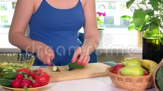 孕妇的大肚子和厨房桌上切黄瓜的手视频