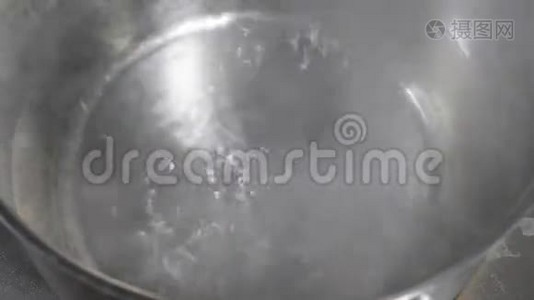 再培训厨房的电炉上锅里烧水。 在不锈钢锅里。视频