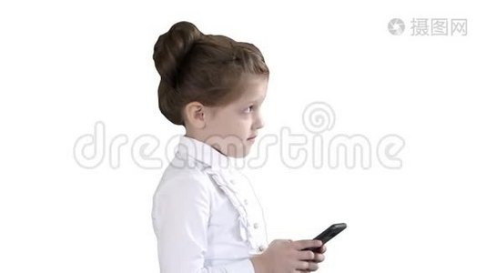 小女孩在白色背景上使用手机智能手机。视频