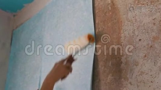一张蓝色墙纸的女士手纸用一种特殊的施工滚筒粘在墙上视频