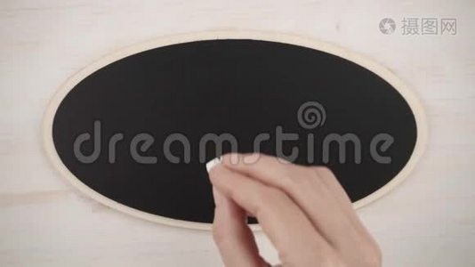 一个女人的手在黑板上用白垩画`一颗手工的心视频